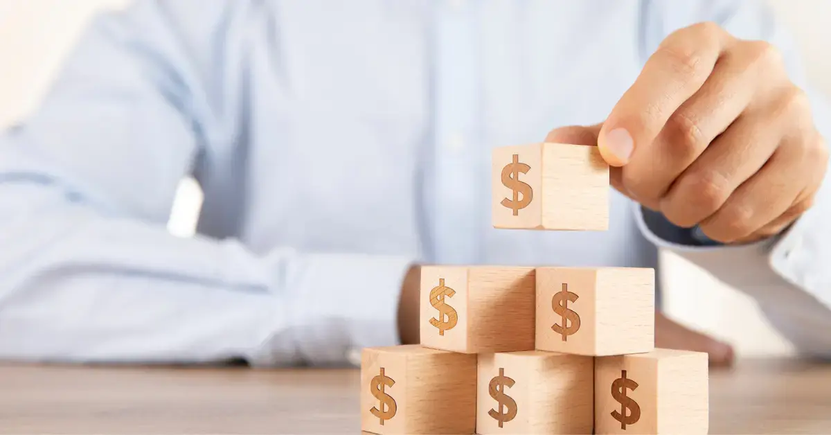 Man placing blocks with dollar sign